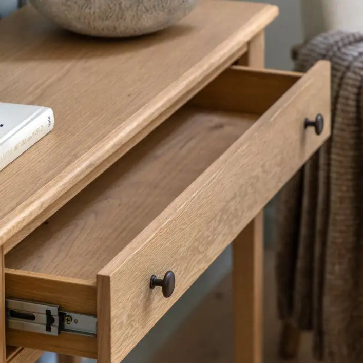 Gallery Direct Malvern Console Table features 1 wide drawer with metal handles and is constructed from premium oak solids and veneers with wood-grain patterns