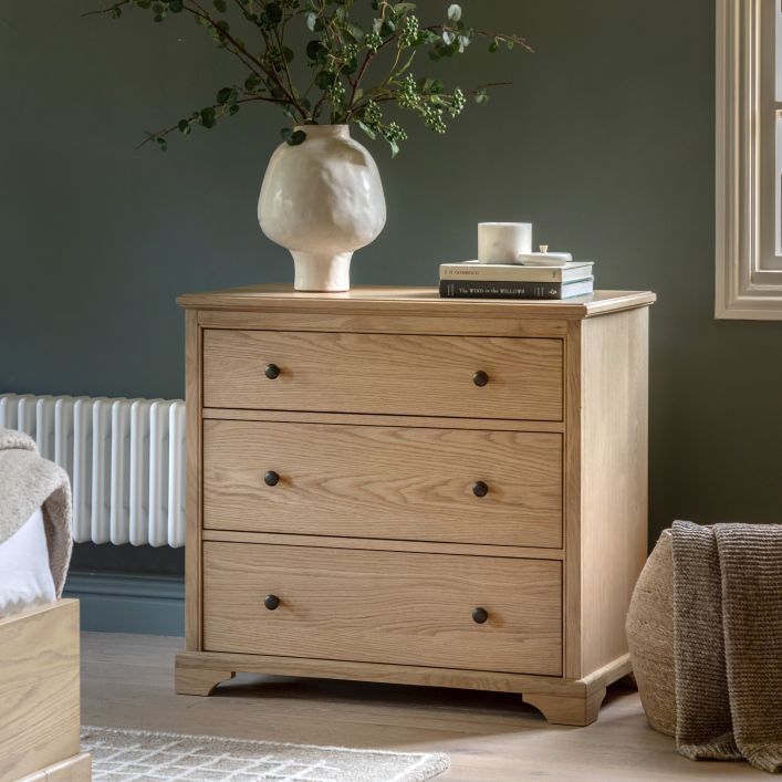 Gallery Direct Malvern 3 Drawer Chest is constructed from premium solid oak and veneers with warm wood-grain patterns and contrasting dark metal drawer knobs