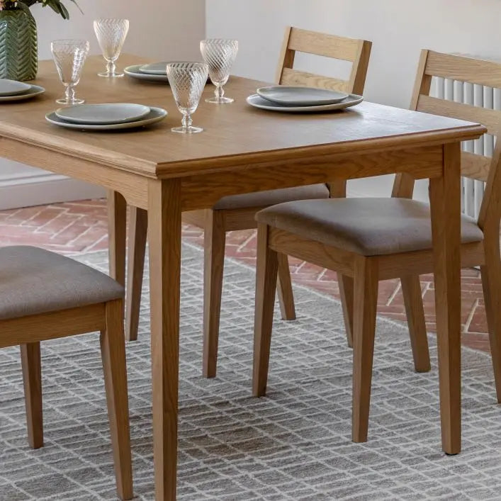 Gallery Direct Malvern Extending Dining Table is made using premium oak solids and veneers with a natural wood-grain patterned finish, and slim tapered legs