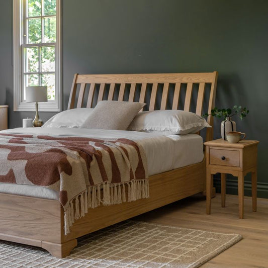 Gallery Direct Malvern King Size Bed with a platform style frame and a slatted supportive headboard, constructed from solid oak wood and veneers with a natural wood-grain pattern throughout