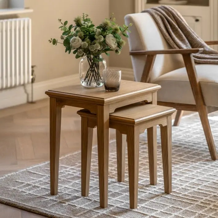 Gallery Direct Malvern Nest of 2 Stackable Side Tables, constructed from warm natural oak wood and veneers with wood grain pattern, and slim tapered legs