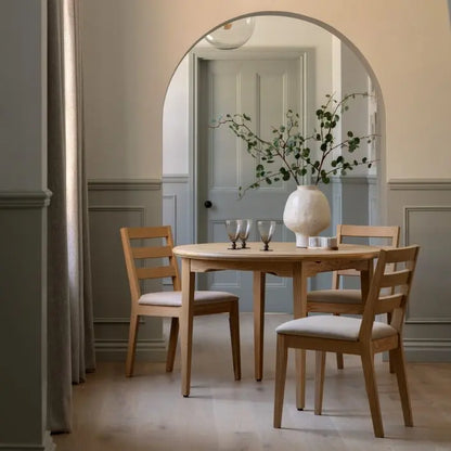 Gallery Direct Malvern Round Extending Dining Table can seat 4-6 when extended, crafted from warm oak wood and veneers with a wood-grain pattern finish and slim tapered legs 