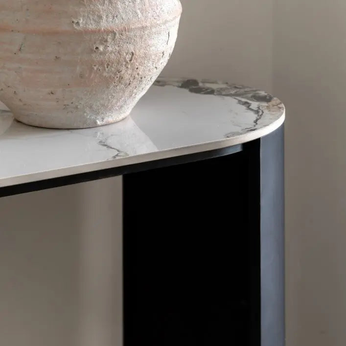 The Gallery Direct Marzio Console Table has a contemporary design and is constructed from a luxurious Carrara marble table top and sleek black metal curved legs 