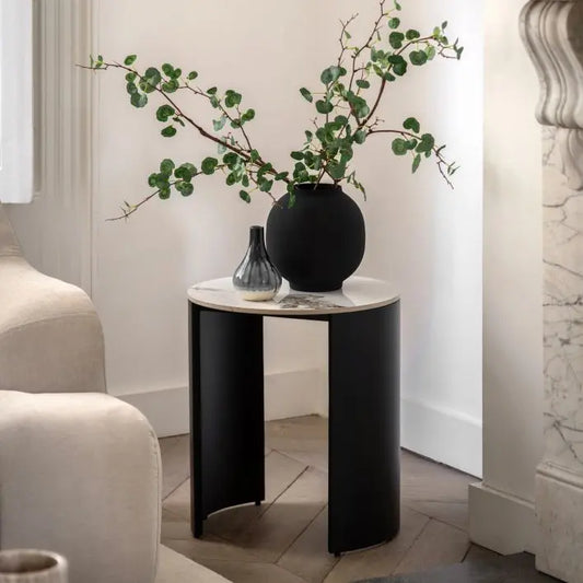 Gallery Direct Marzio Side Table features a luxurious Carrara marble stone top, with individual natural veining, and contrasting matt black metal legs