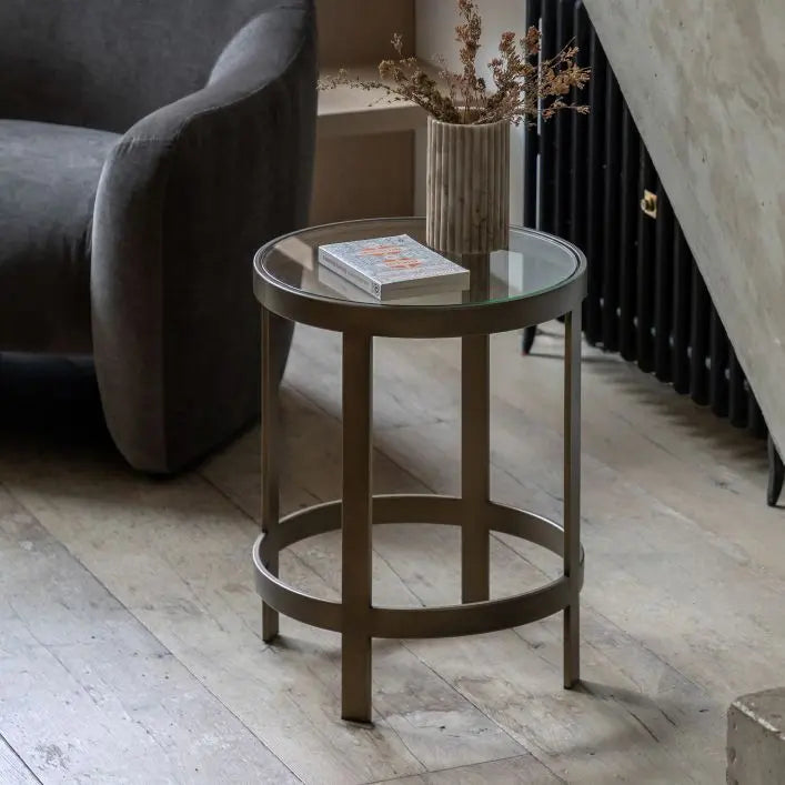 The Gallery Direct Monti Round Side Table features a bronze metal frame with a toughened glass table top