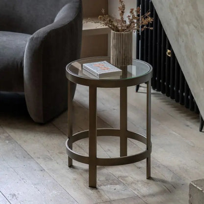 The Gallery Direct Monti Round Side Table features a bronze metal frame with a toughened glass table top