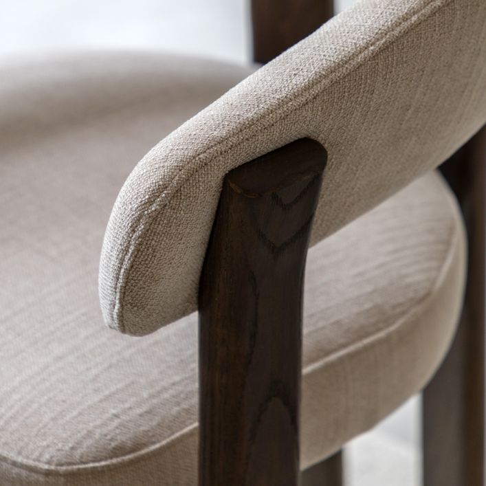 Gallery Direct Onda Dining Chair features a curved back and armrest in a Natural linen padded upholstery with a dark wood frame