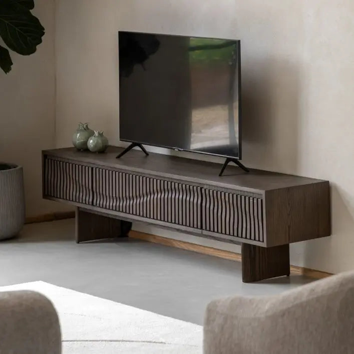 The Gallery Direct Onda Media Unit is an Italian inspired piece made from solid oak and veneers in a charcoal brown finish, with a striking slatted wave design to the cupboard front