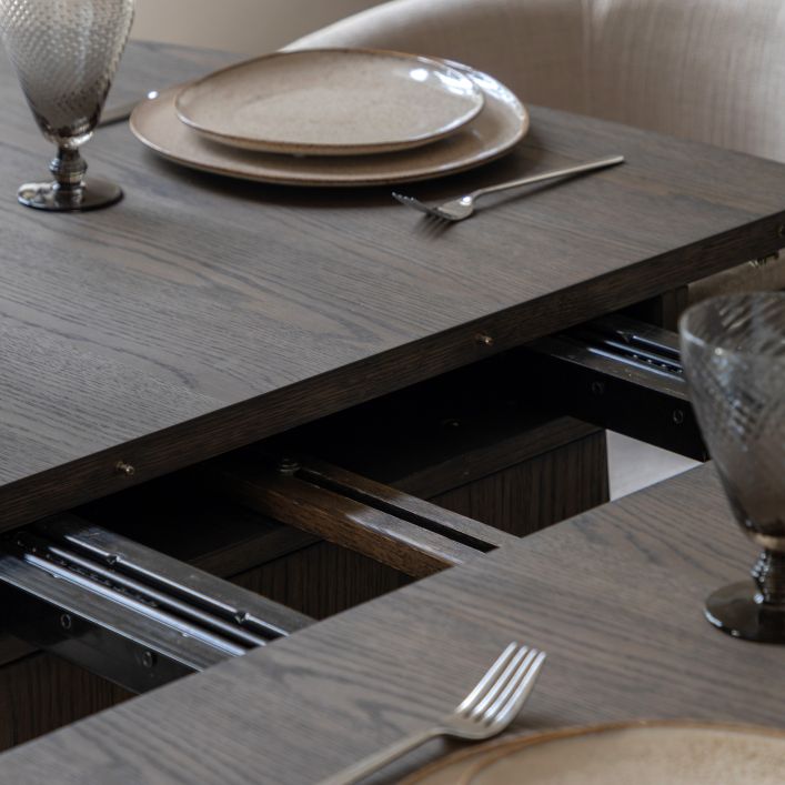 Gallery Direct Onda Oval Extending Dining Table constructed in a charcoal brown oak wood and veneers, with a seamless extending mechanism that can seat up 6 people