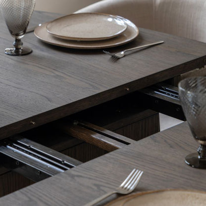 Gallery Direct Onda Oval Extending Dining Table constructed in a charcoal brown oak wood and veneers, with a seamless extending mechanism that can seat up 6 people