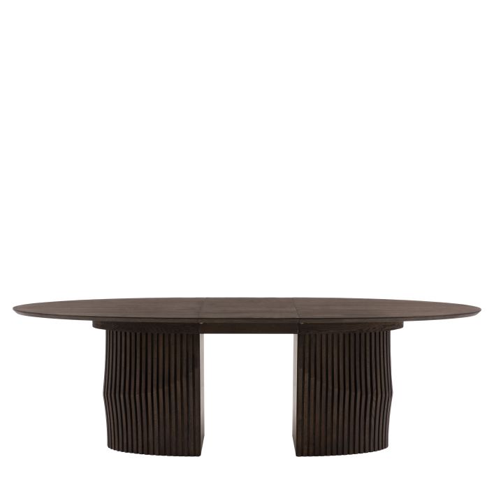 Gallery Direct Onda Oval Extending Dining Table features a striking thick wooden base with a slatted wave design, and a sleek oval table top constructed from oak wood and premium veneers
