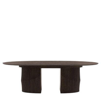 Gallery Direct Onda Oval Extending Dining Table features a striking thick wooden base with a slatted wave design, and a sleek oval table top constructed from oak wood and premium veneers