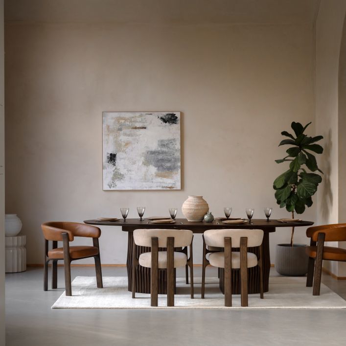 The Gallery Direct Onda Oval Extending Dining Table constructed from solid oak wood and veneers in a charcoal brown finish, is an Italian inspired table with slatted wave design chunky base and a sleek table top that can seat up to 6.