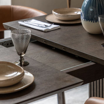 The Gallery Direct Onda Rectangular Dining Table features an extending mechanism in a charcoal brown finish