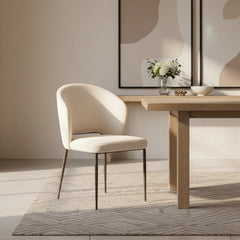 The Gallery Direct Pair of Cosenza Dining Chairs are fully upholstered in a soft Vanilla coloured fabric, with bronzed metal legs