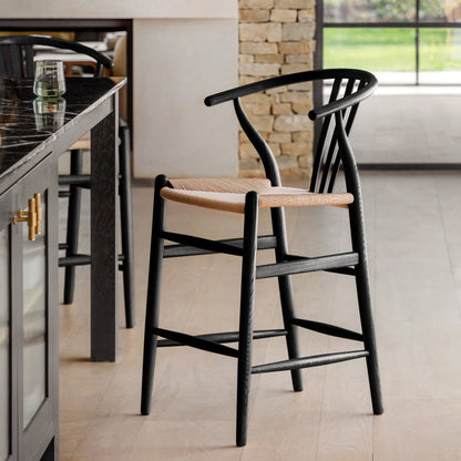 Gallery Direct Pair of Whitney Bar Stools in Black painted wood with a wishbone backrest, rope woven seat and a footrest bar