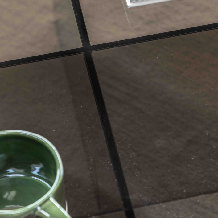 Gallery Direct Parioli Coffee Table has a toughened glass table top and cross legged base in a Charcoal brown colour