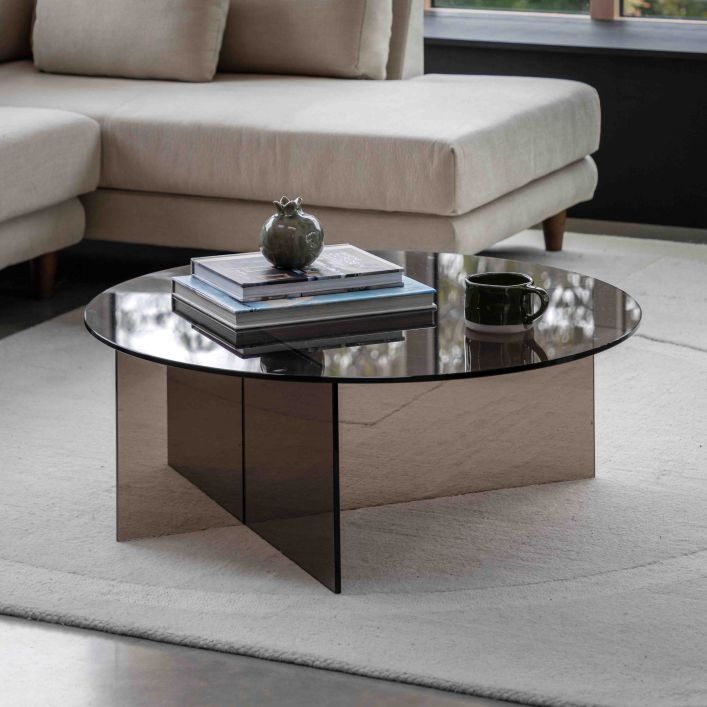 The Gallery Direct Parioli Coffee Table has a round toughened glass table top and matching cross legged base, in a Charcoal brown tone