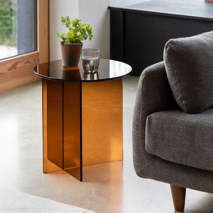 The Gallery Direct Parioli Round Side Table has a toughened glass table top and cross legged base in a Bronze tone