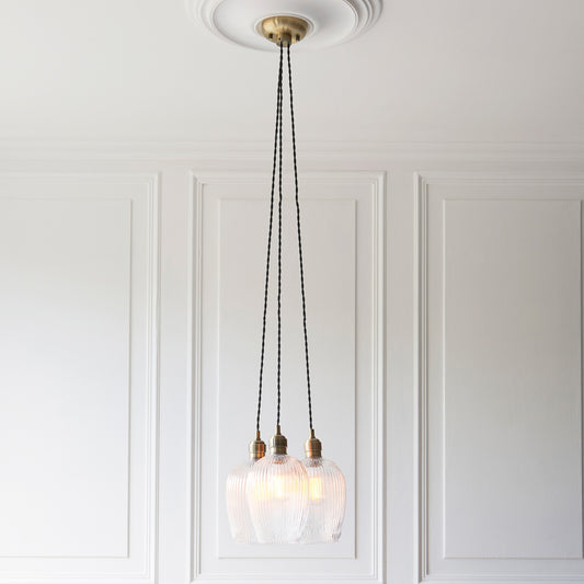 Gallery Direct Polaris 3 Ribbed Cluster Pend Light Antique Brass, styled in a room setting