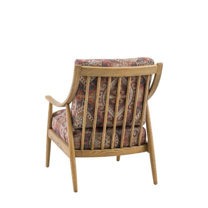 The Gallery Direct Reliant Armchair features an ash wood frame with spindle backrest and seat cushions upholstered in a striking Zari Jacquard pattern 