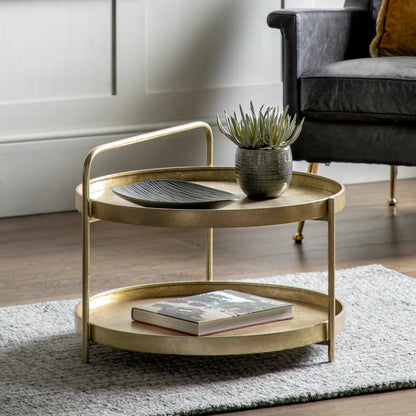 The Gallery Direct Sennen Metal Coffee Table has a distinctive tray-style table top and lower shelf with curved handle element in Gold leaf finish