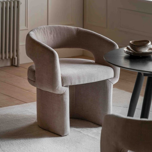 The Gallery Direct Sloane Dining Chair is gently curved for a contemporary silhouette, fully upholstered in a Natural toned fabric for exceptional comfort