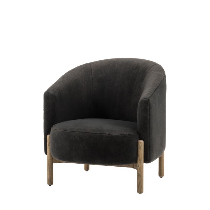 The Gallery Direct Tindon Armchair is upholstered in a soft plush Alaska Graphite coloured faux fur, with contrasting light wood base and legs