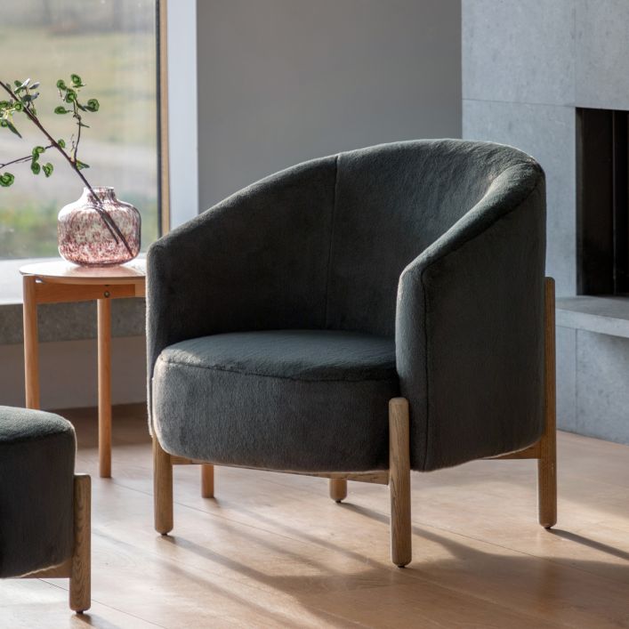 The Gallery Direct Tindon Curved Armchair is upholstered in Alaska Graphite soft plush faux fur material with a solid wood base and legs