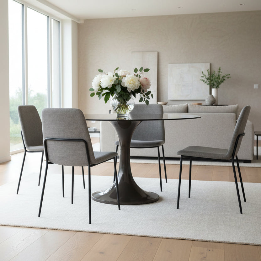 The Gallery Direct Tivoli Round Dining Table is constructed from glass reinforced concrete (GRC) for the fluted base and a subtly tinted toughened glass table top, in a rich brown colour palette 