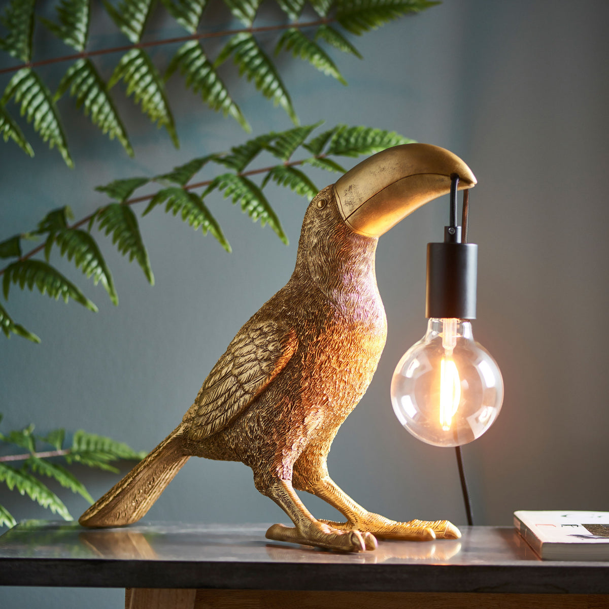 Gallery Direct Toucan Table Lamp Gold, styled in a room setting