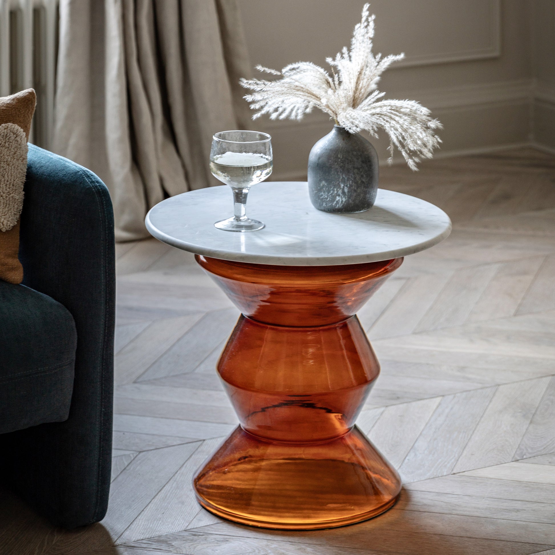 Gallery Direct Turin Side Table in Orange features a white marble table top and a glass base