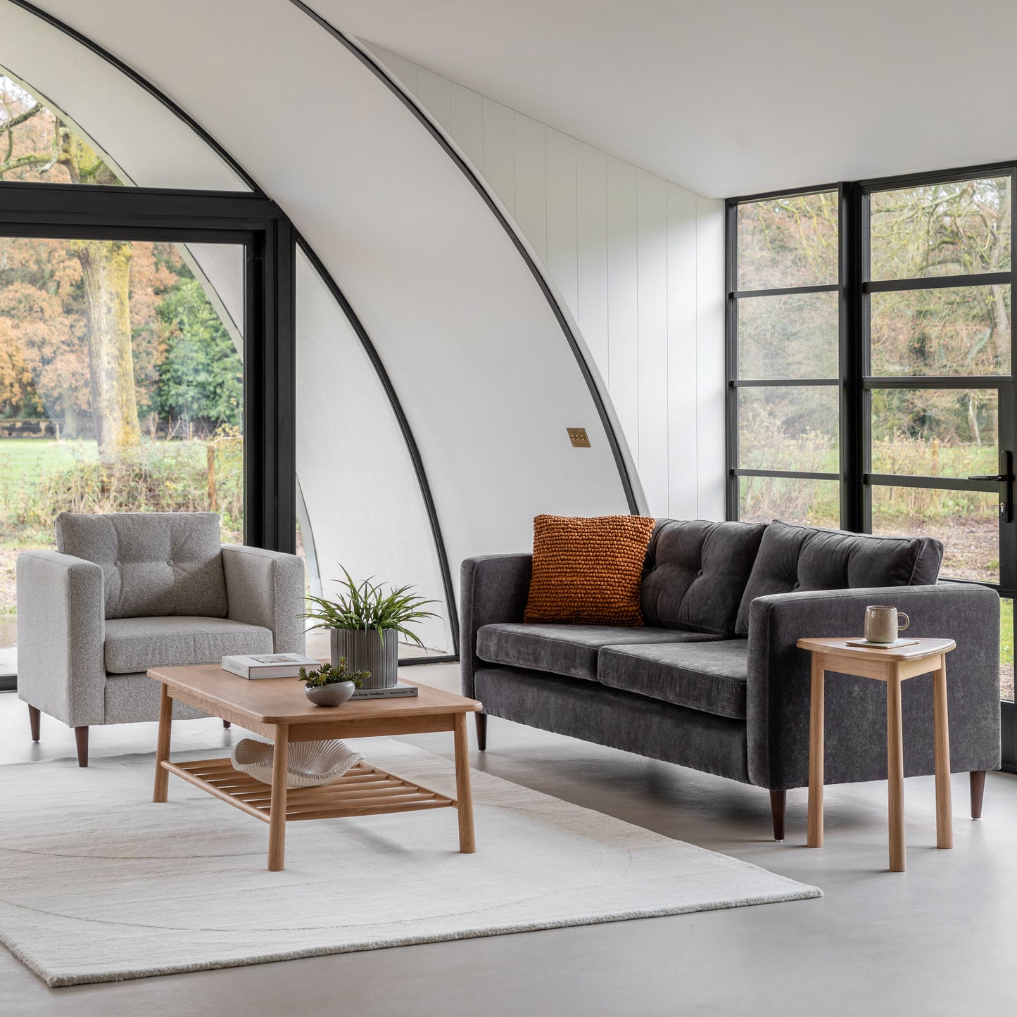 Gallery Direct Whitwell Armchair upholstered in a Light Grey fabric, with button tufted back cushion, distinctive block arms and tapered wooden legs