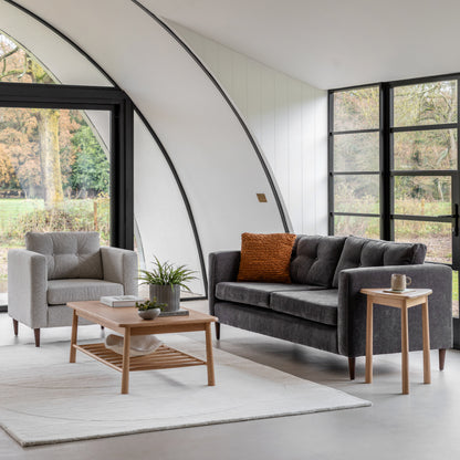 Gallery Direct Whitwell Armchair upholstered in a Light Grey fabric, with button tufted back cushion, distinctive block arms and tapered wooden legs