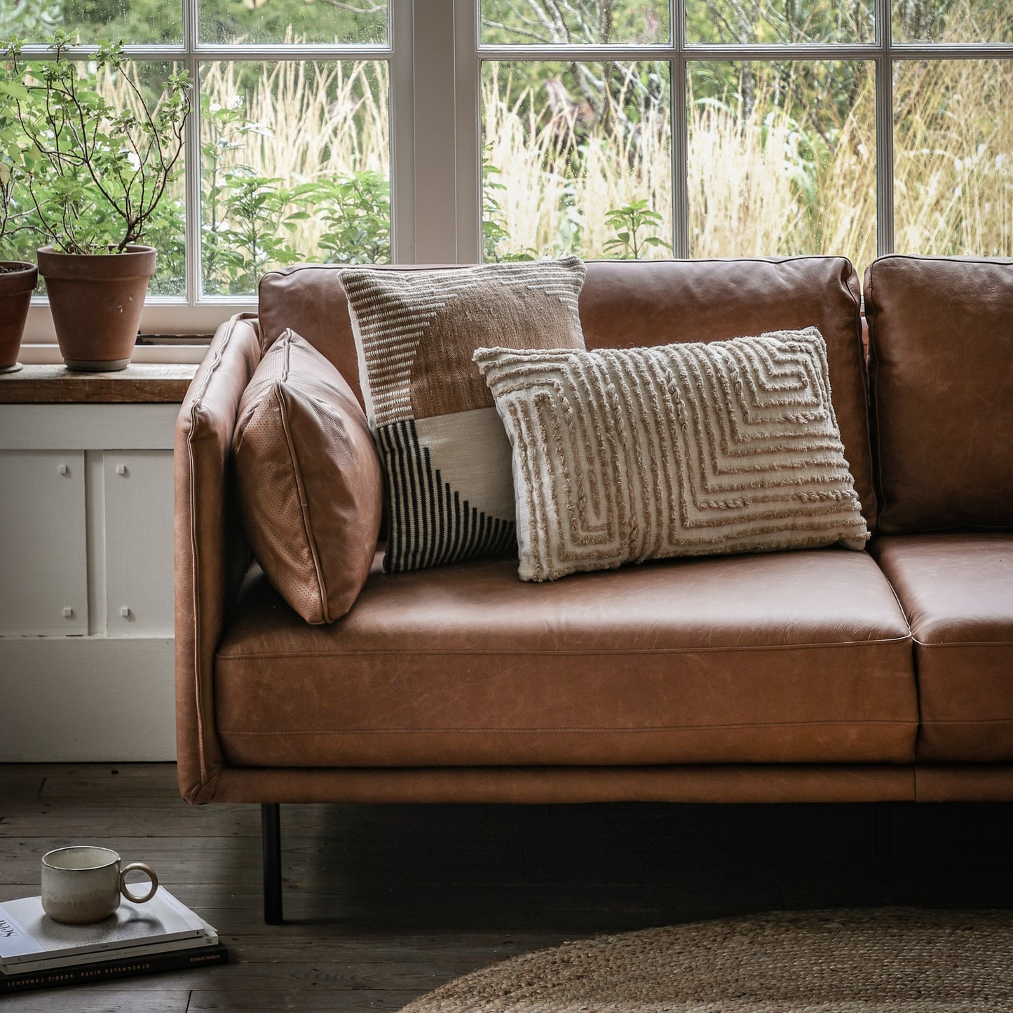 Gallery Direct Wigmore 3 Seater Sofa Upholstered in a Warm Brown Leather with matching side cushions and sleek black metal legs 