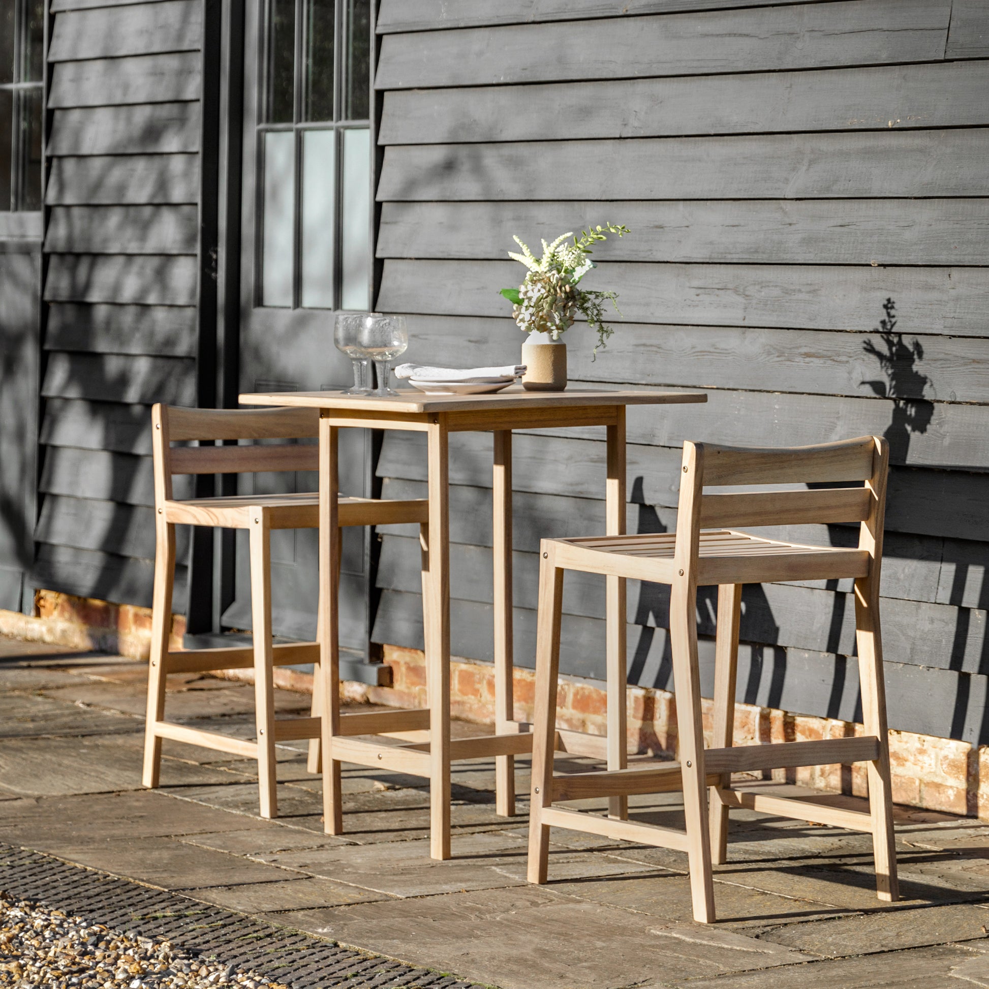 Gallery Garden Astakos High Bar Set features a high table with square slatted wood top, and 2 bar chairs with low backrest and slatted wood seat
