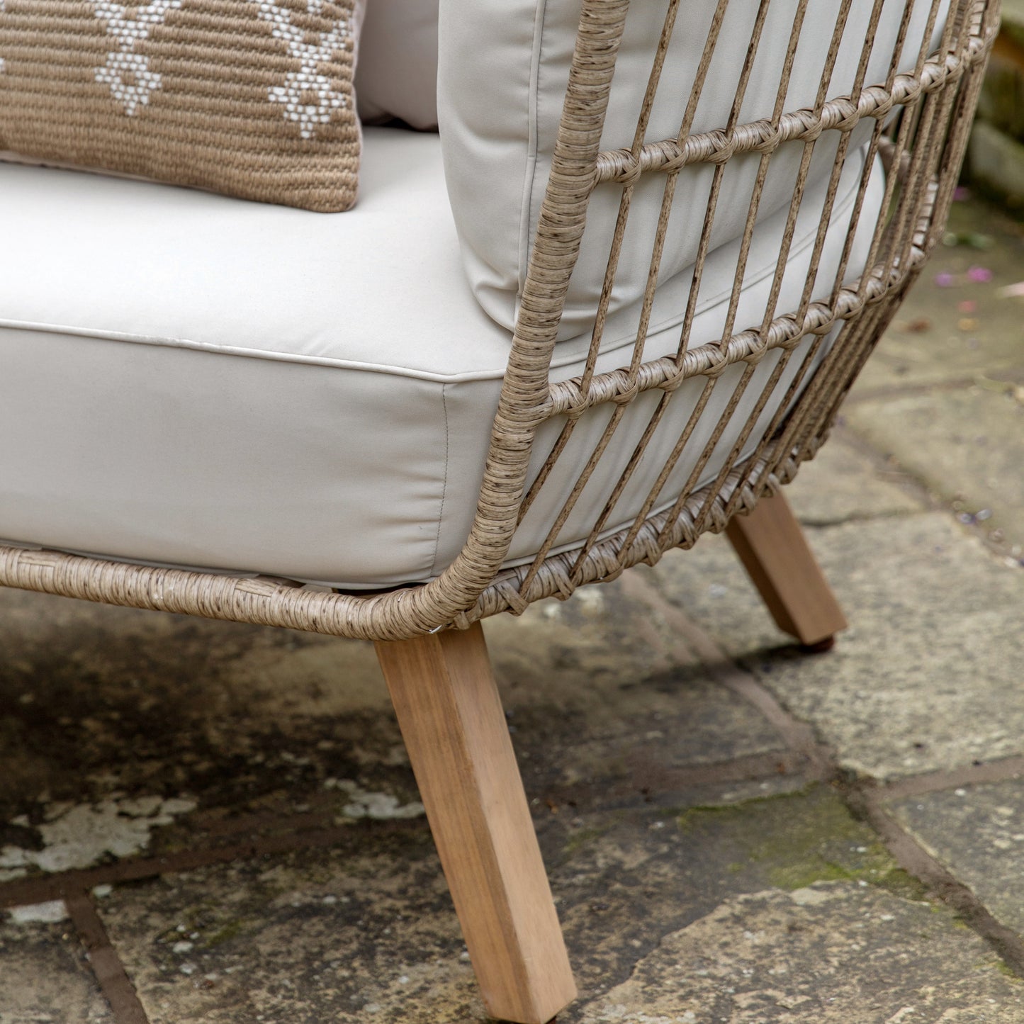 Gallery Garden Avena Egg Chair features a natural coloured wickerwork frame, oiled acacia wood legs and cream seat cushions