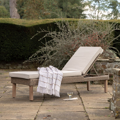 Gallery Garden Avena Sun Lounger features a poly-rattan wicker frame and plush cushions with adjustable backrest for upright and reclining functions