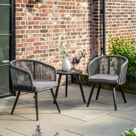 Gallery Garden Cassis Bistro / Tea Set features 2 armchairs with a rounded open rope-weave back design, powder coated aluminium frame and legs, and a grey padded seat cushion. Plus a matching small round side table