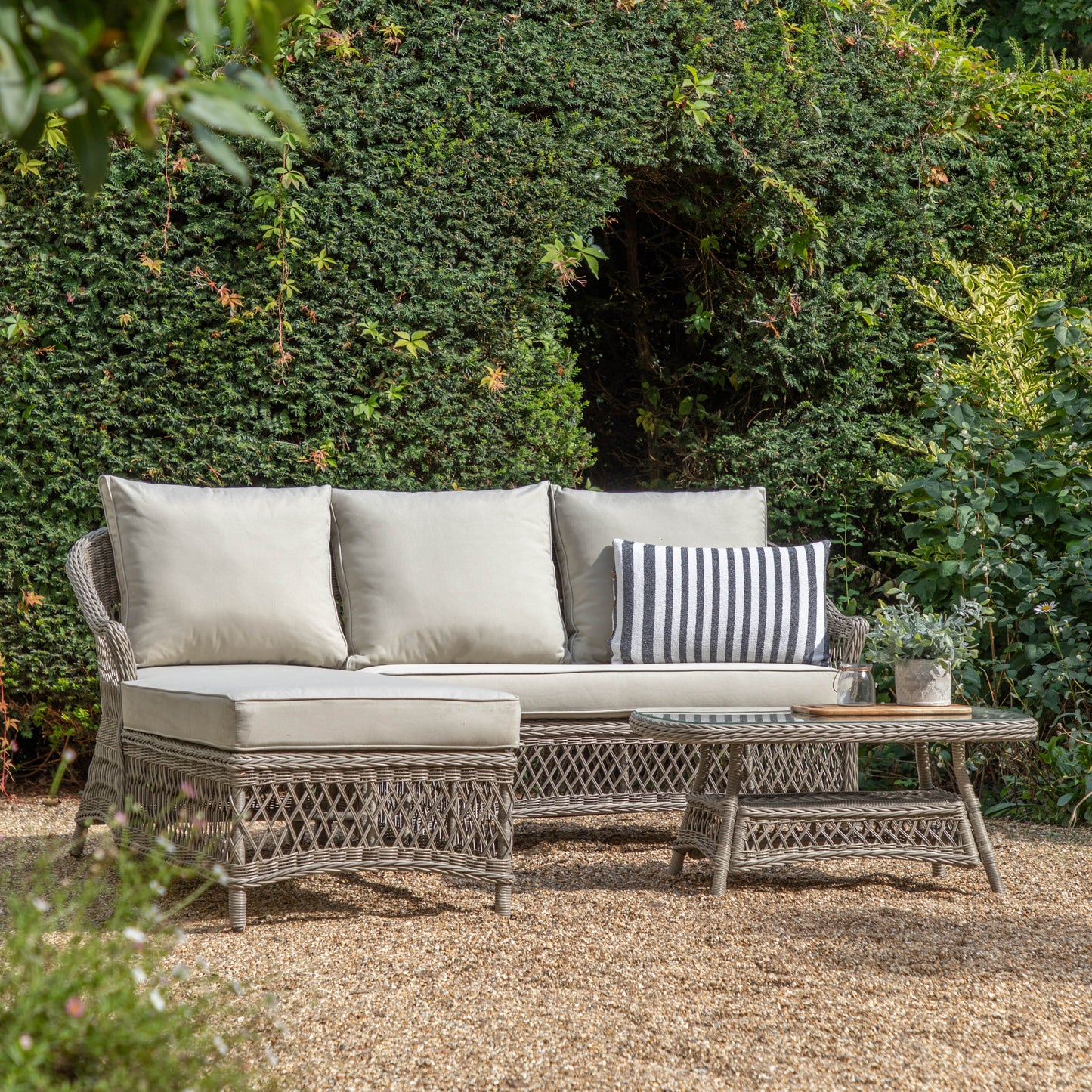 Gallery Garden Menton Chaise 3 Seater Set in a Stone coloured PE rattan with generously padded cushions, and a matching rattan coffee table with glass table top