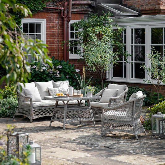 Gallery Garden Menton Country Sofa Dining/Tea Set in Stone, features a 3 seater sofa, 2 armchairs and a dining table with glass top, constructed from a durable PE wicker, with plush seat cushions