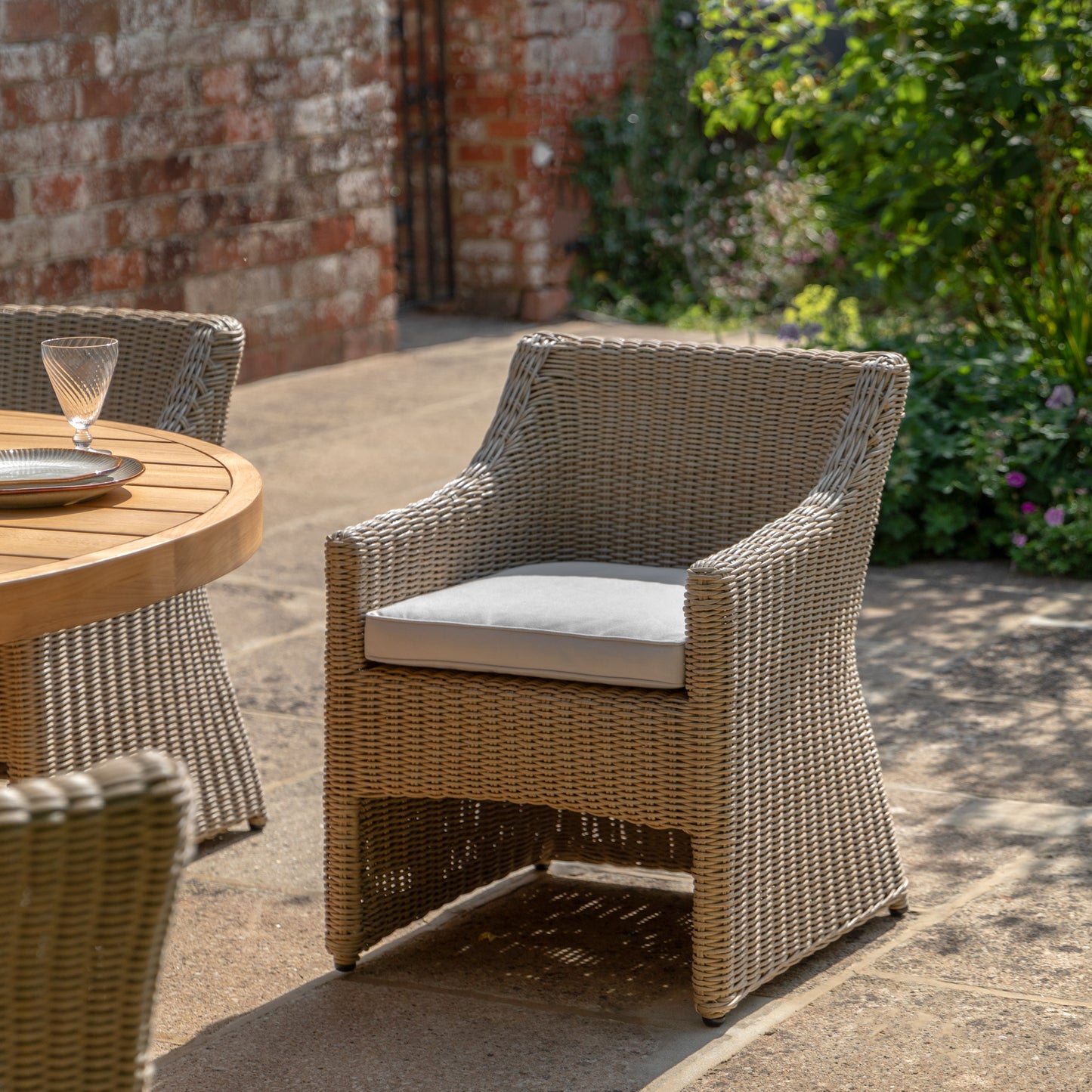 Gallery Garden Pair of Chatsworth Dining Chairs made from durable and weather resistant plastic wicker, with a ergonomic design and natural coloured seat cushions