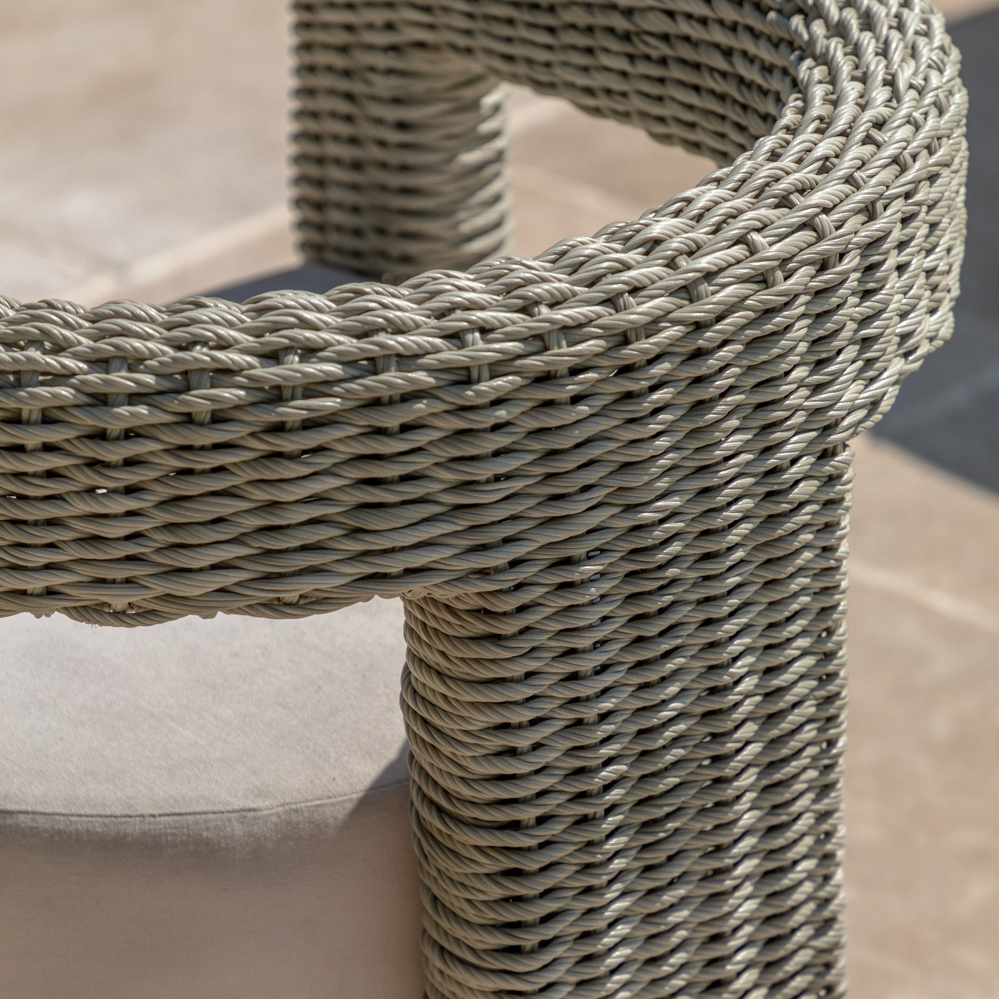 Gallery Garden Hvar Dining Chairs features a curved frame made from grey toned wicker, with a natural coloured padded seat cushion