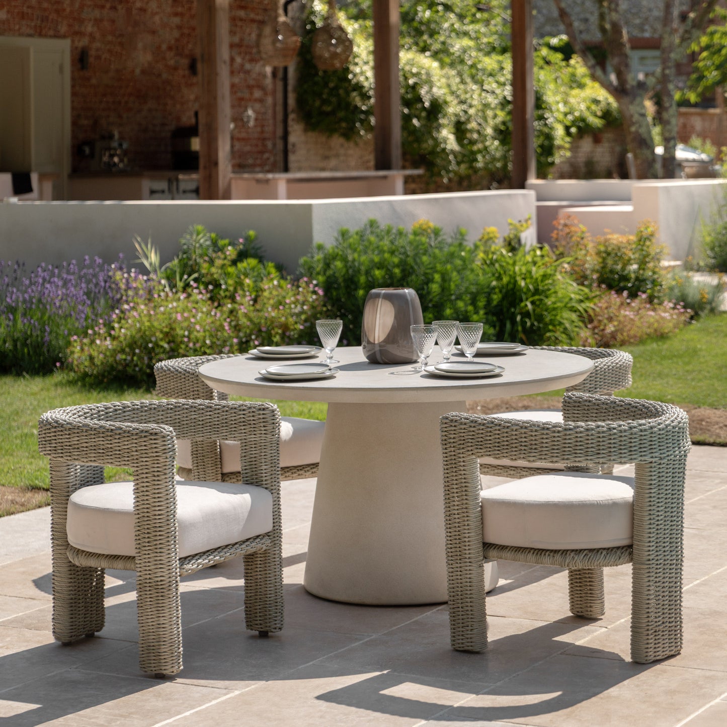 Gallery Garden Pair of Hvar Dining Chairs constructed from grey toned wicker with a curved 3 legged design, finished with a deep filled seat cushion