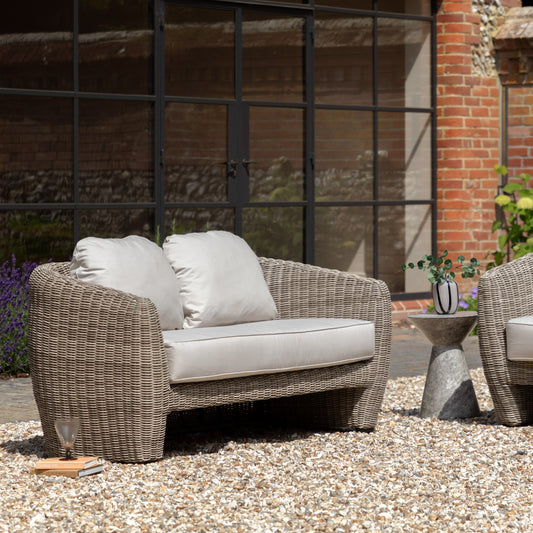 Gallery Garden Positano 2 Seater Sofa featuring sleek curved lines and a sophisticated grey finish, crafted from weather-resistant woven wicker, with generously padded foam-filled cushions for exceptional comfort