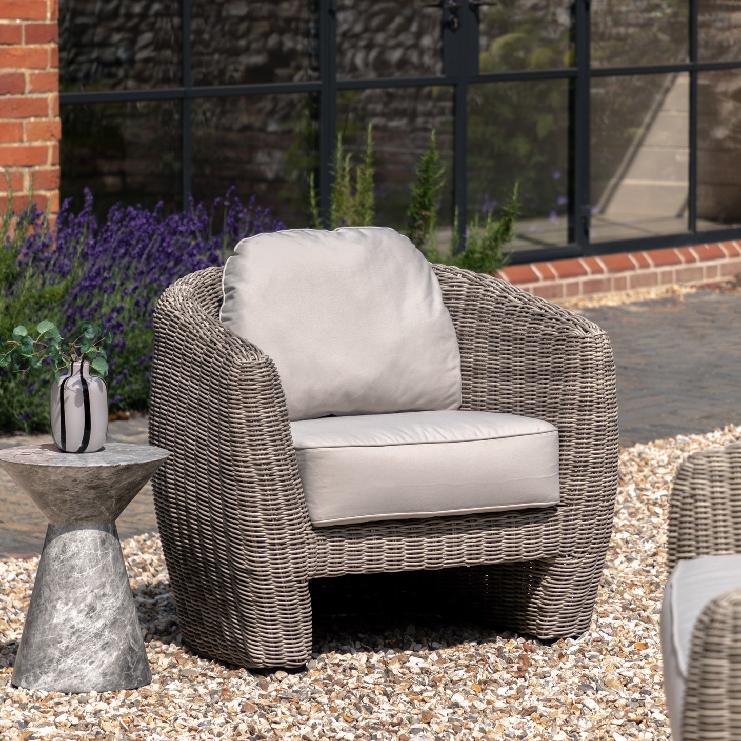 Gallery Garden Positano Outdoor Armchair is constructed from a resilient woven plastic wicker with curved shape, and features deep filled natural coloured seat cushions