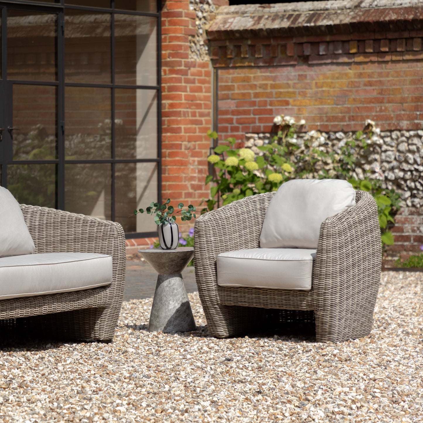 Gallery Garden Positano Armchair featuring gracefully curved lines and understated tones, constructed from resilient woven plastic wicker, it's paired with a generously cushioned foam seat for extended comfort.