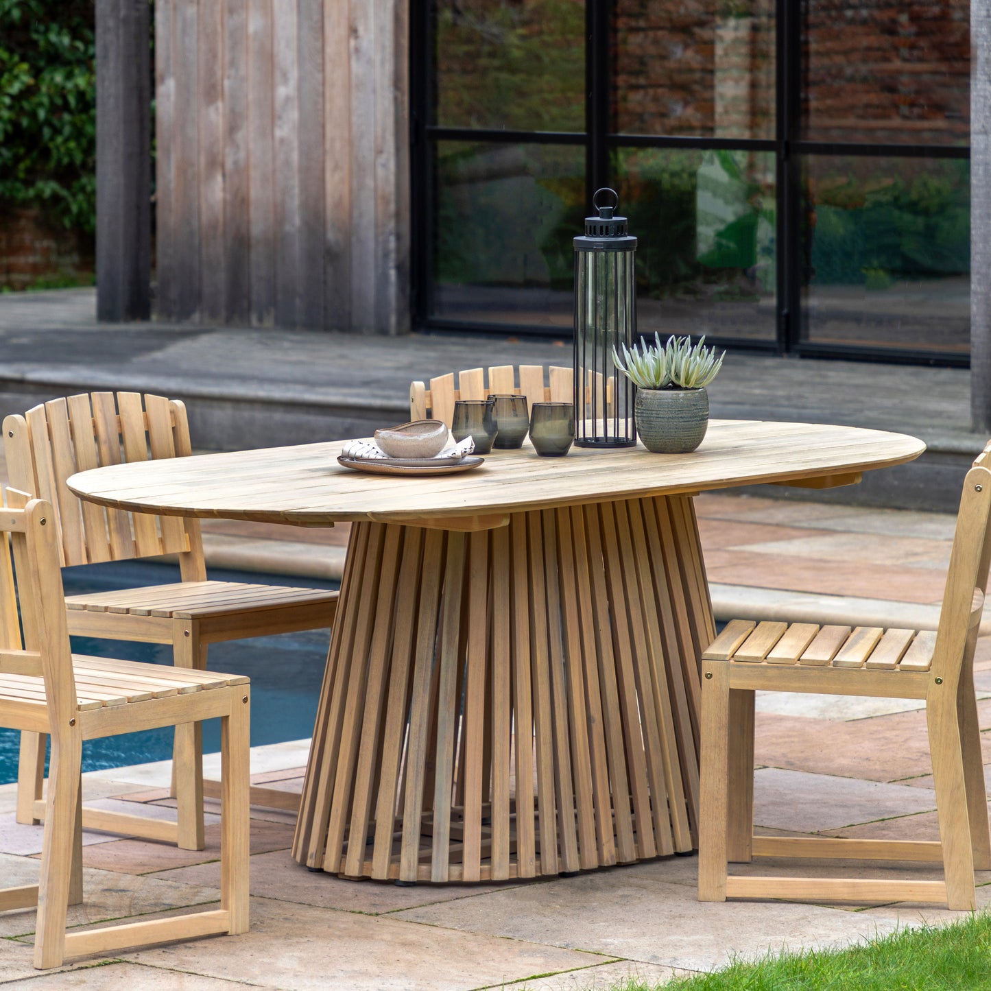 Gallery Garden Rialto Oval Dining Table can seat up to 6 people and features a slatted wood table top and a striking slatted base, made from premium acacia wood