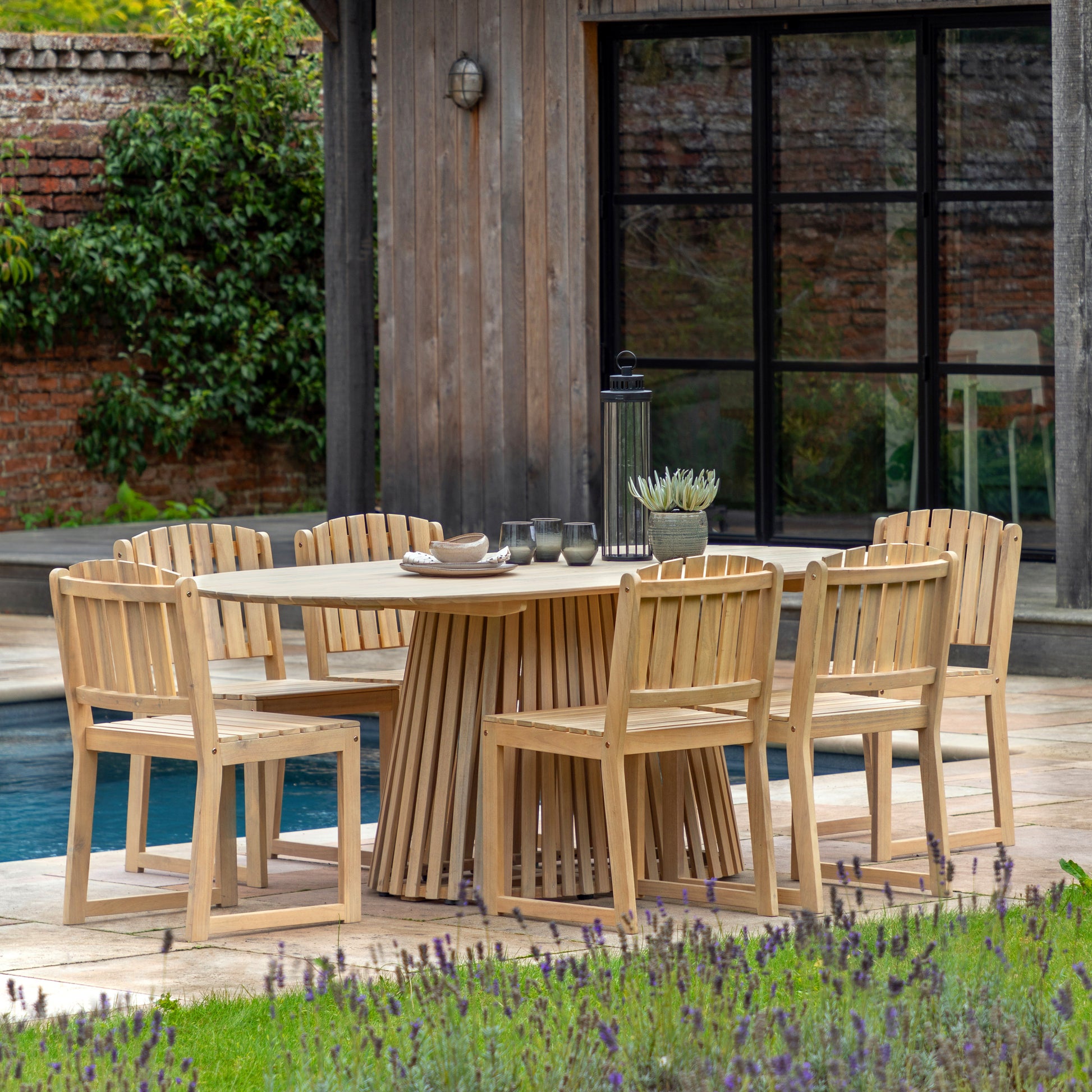 Gallery Garden Rialto 6 Seater Dining Table is crafted from premium acacia wood with a slatted oval table top and a striking slatted wood base