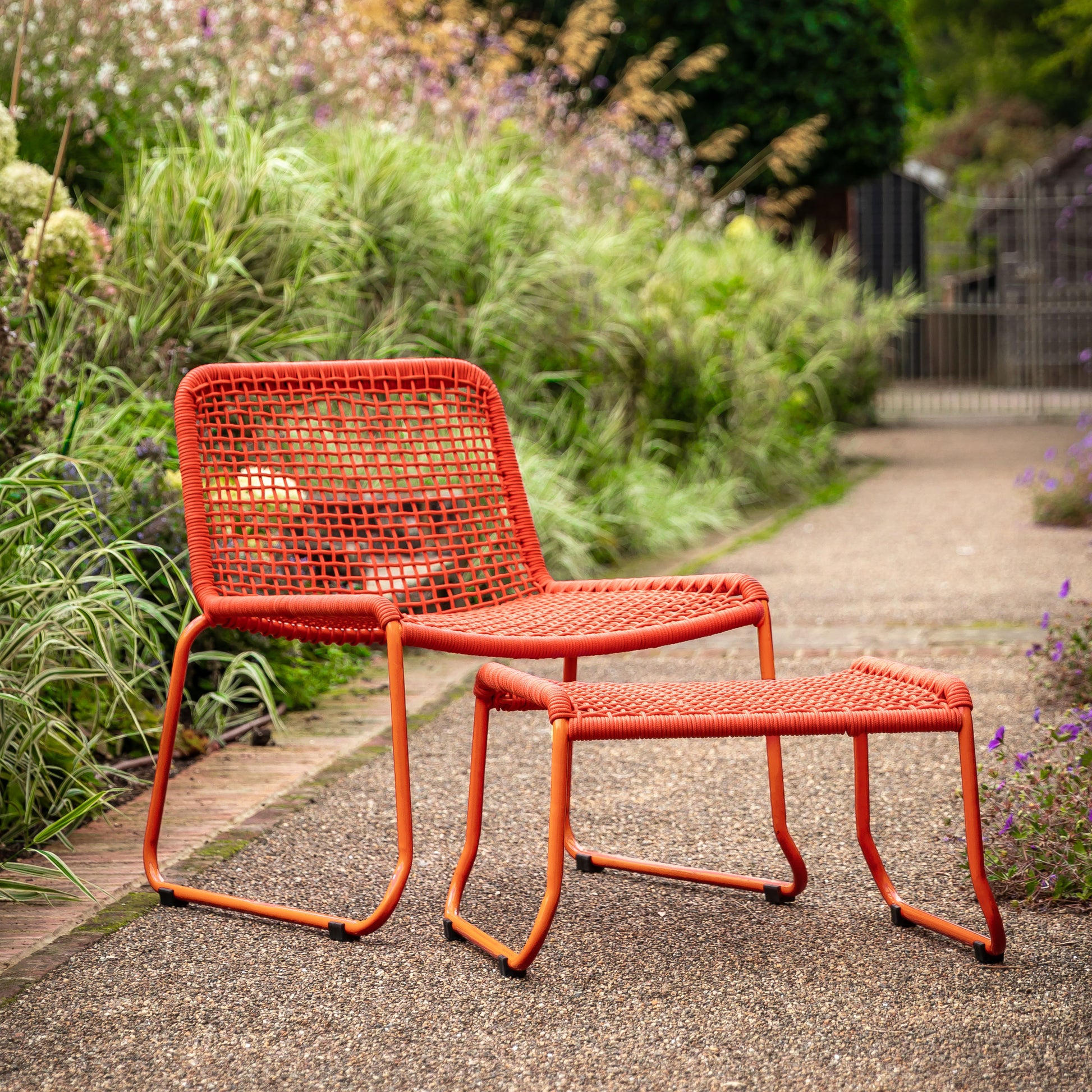 Gallery Garden Sassano Lounge Chair and Footstool in a vibrant Orange colour, constructed from a robust steel frame with a rope woven seat and back rest